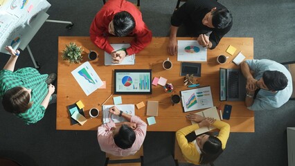 Naklejka premium Top view of investor looking executive manager standing and presenting plan. Attractive businesswoman standing whiteboard and holding tablet display financial graph at business meeting. Convocation.