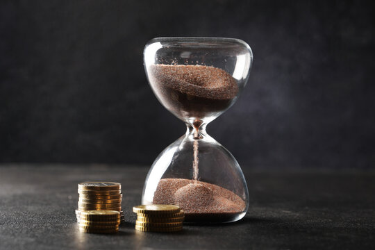 Hourglass with falling sand and euro coins, time management and financial investment concept, business planning and wealth growth