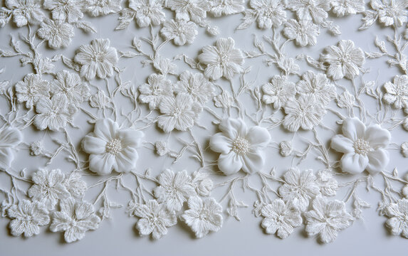 Closeup of textured fabric pattern with elegant vintage lace and floral hand embroidery on a white background. Decorative wedding design.
