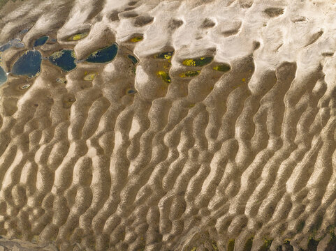 Aerial view of intricate sand dunes and small pools of water forming patterns in a riverbed near Bogura, Rajshahi Division, Bangladesh.