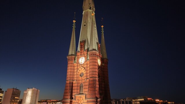 Aerial view of Saint Clara Church (Klara kyrka) in Norrmalm, downtown Stockholm, Sweden. Cinematic drone shot of the iconic Gothic Revival brick tower and cityscape.