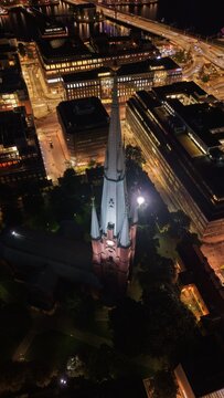 Aerial view of Saint Clara Church (Klara kyrka) in Norrmalm, downtown Stockholm, Sweden. Cinematic drone shot of the iconic Gothic Revival brick tower and cityscape.