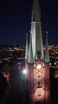 Aerial view of Saint Clara Church (Klara kyrka) in Norrmalm, downtown Stockholm, Sweden. Cinematic drone shot of the iconic Gothic Revival brick tower and cityscape.