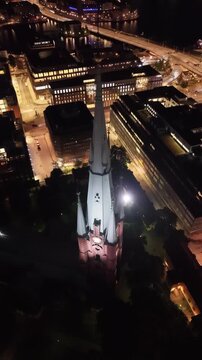 Aerial view of Saint Clara Church (Klara kyrka) in Norrmalm, downtown Stockholm, Sweden. Cinematic drone shot of the iconic Gothic Revival brick tower and cityscape.