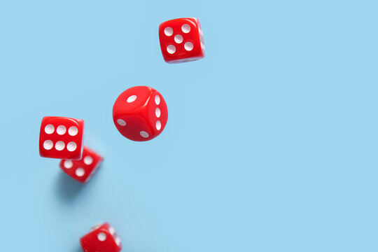 Flying red game dices on blue background