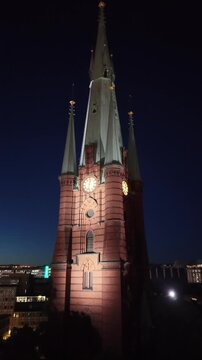 Aerial view of Saint Clara Church (Klara kyrka) in Norrmalm, downtown Stockholm, Sweden. Cinematic drone shot of the iconic Gothic Revival brick tower and cityscape.