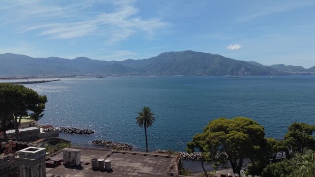 Panoramic view of Villa Rossi Filangieri terrace with pine and palm trees overlooking Gulf of Naples and Sorrentine mountains, Torre Annunziata, Italy
