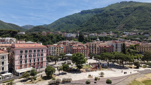 Aerial view of Castellammare di Stabia Villa Comunale square with Cassa Armonica gazebo, colorful buildings and lush Monte Faito mountain, Naples, Italy