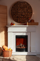Obraz premium Fireplace with Halloween pumpkins, burning candle and mirror in living room