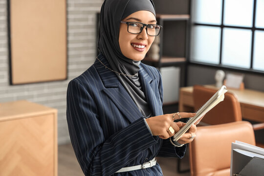 Muslim businesswoman working with notebook in office