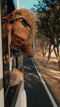 Adult traveler woman outside the window of her modern van camper . Concept of transport and rv vehicle for summer holiday vacation, People enjoying trip on the road. Van life and freedom concept
