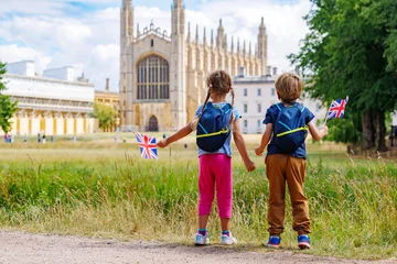 Two children with backpacks waving British flag visit Cambridge © Sergey Novikov