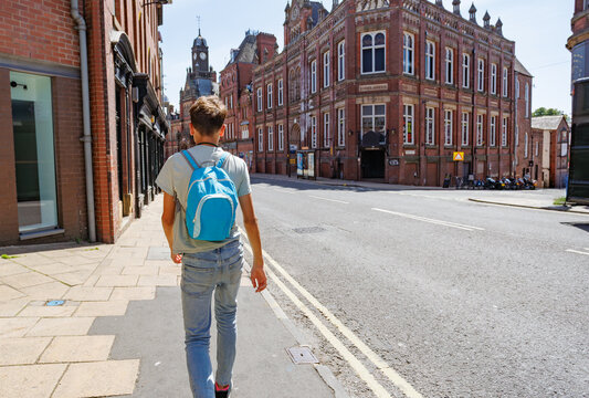 Teenage boy with backpack walking along Clifford street, York