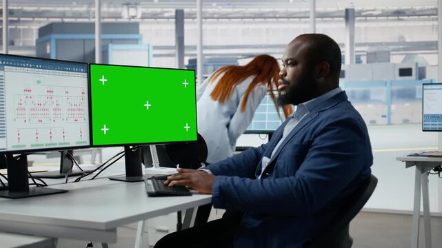 Man analyzing PCB architecture on green screen mockup PC in semiconductor factory office, monitoring microchip parts fabrication, chroma key computer and African American engineer.