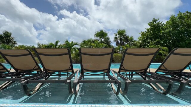 Luxury poolside lounge chairs with tropical view