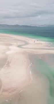 Amazing tropical beach anc blue transparent sea ocean water. Aerial view of coastline and amazing seascape landscape with horizon and sky and mountains in background. Summer travel