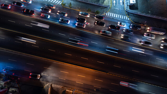 Aerial view of a busy highway at night with light trails from moving vehicles and illuminated road markings in the Dominican Republic.