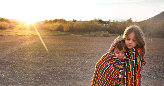 kids wrapped in blanket in desert landscape