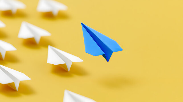 Blue paper airplane lead white ones on yellow background, symbolizing innovation, leadership, unique ideas, and breaking from the crowd