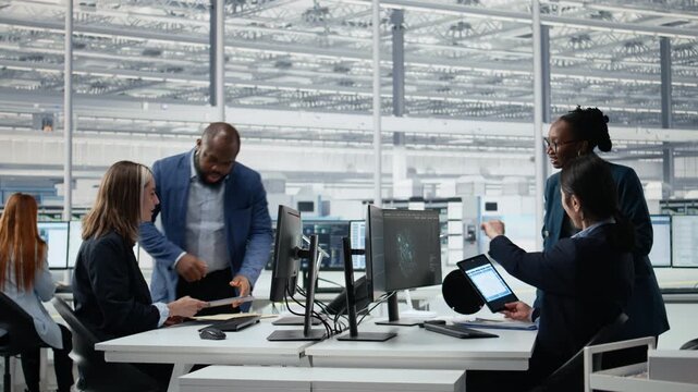 Timelapse of diverse engineering team in microchip factory lab analyzing chip architecture with AI, teamwork diverse colleagues using machine learning on PC in semiconductor lab office.