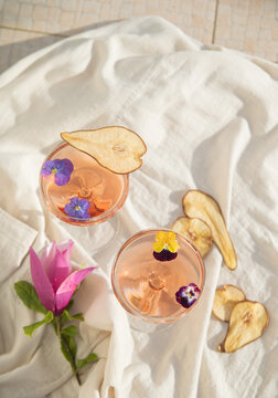 Two rose wine glasses on white fabric top view. Summer cocktails