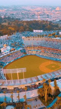 View of Dodger Stadium and surrounding area in Los Angeles during evening with sunset and crowds in the stadium