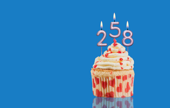 Birthday Or Anniversary Cupcake With Lit Candles; Candles Forming The Number 258