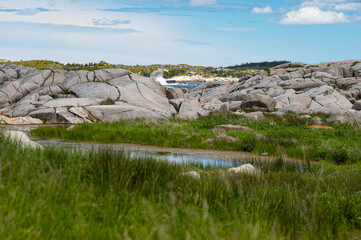 A powerful coastal landscape showing the Atlantic Ocean surf breaking over smooth granite formations on the rugged South Shore of Nova Scotia, Canada. © Lisa