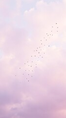 Obraz premium Silhouetted Birds Migrating Across a Pastel Sky
