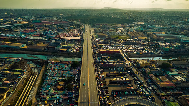 Aerial view of Kwame Nkrumah Circle, featuring the elevated highway interchange, urban markets, and dense city infrastructure in Accra, Greater Accra Region, Ghana.