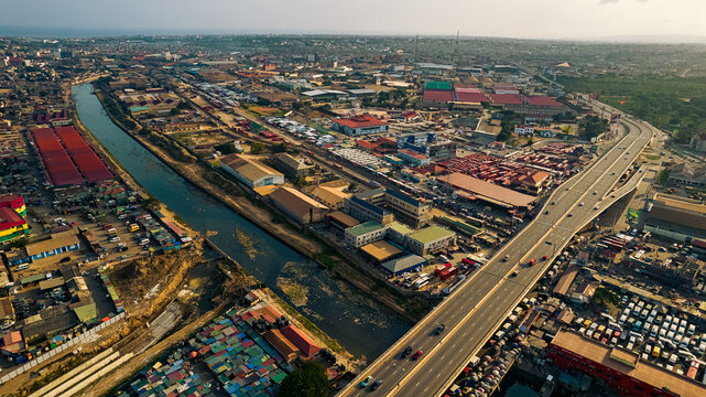 Aerial view of the Kwame Nkrumah Circle area featuring the elevated highway, urban infrastructure, commercial buildings, and a canal in Accra, Greater Accra Region, Ghana.