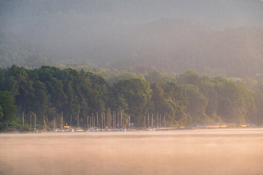 Sailboats moored in a misty marina at sunrise, Żywiec Lake