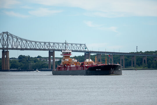 PERTH AMBOY, NEW JERSEY - JUNE 19, 2026: The articulated tug Janice Ann Reinauer pushes tank barge RTC 103 beneath the Outerbridge Crossing.