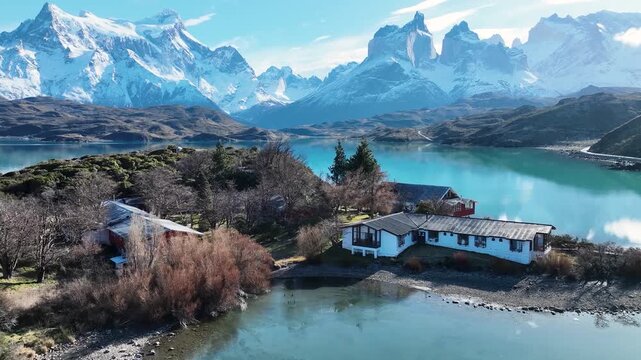 Aerial drone footage of luxurious mountain lodge nestled in Torres del Paine national park landscape.