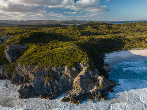 Aerial view of Anvil Beach with rugged cliffs, white sand, and turquoise ocean waves crashing against the coastline in Nullaki, Western Australia, Australia.