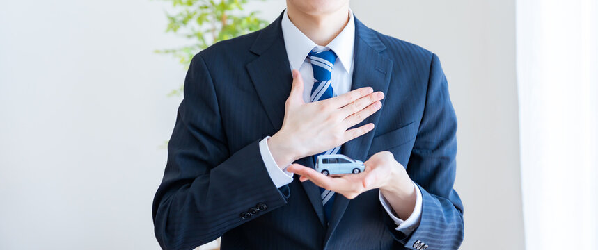 車の模型を持つビジネスマン