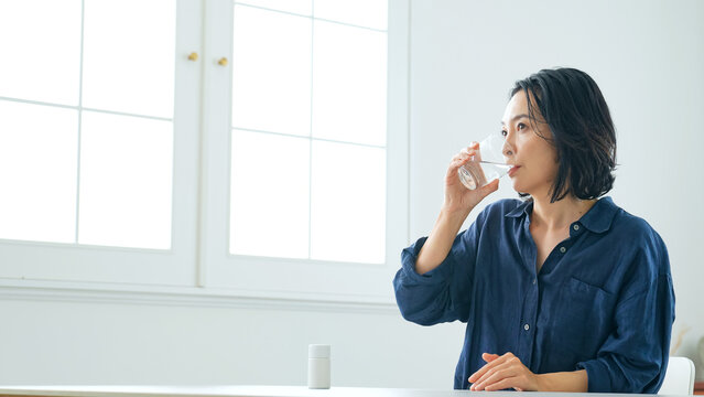 水、コップ、水分補給、飲む、ミネラルウォーター、笑顔、ヘルシー、ヘルスケア、健康、薬、医薬品、クスリ、服薬、ミドル、中高年、女性、日本人、部屋、室内、ライフスタイル、爽やか、スッキリ、爽快、サプリメント、サプリ、グラス、リラックス、飲み物、カジュアル、シニア、美容、明るい、リビング、上半身、健康食品、おいしい、お酒、常備薬、OTC、暮らし、生活、住宅、住まい、食事、ボトル、習慣、ウォーターサーバー
