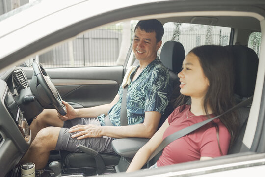 Family, car, driving, father, daughter, lesson, happy middle aged man teaching his teenage girl to drive safely during a road trip, bonding and communicating inside the vehicle.