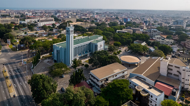 Aerial view of the Holy Spirit Cathedral surrounded by lush trees, urban buildings, and roads in Accra, Greater Accra Region, Ghana.