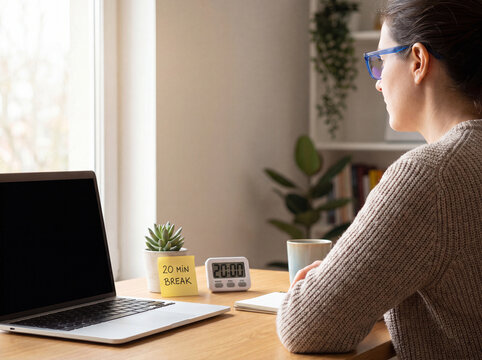 Remote worker taking scheduled break with 20 minute timer and laptop at desk