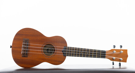 Obraz premium Isolated ukulele on black surface with white background