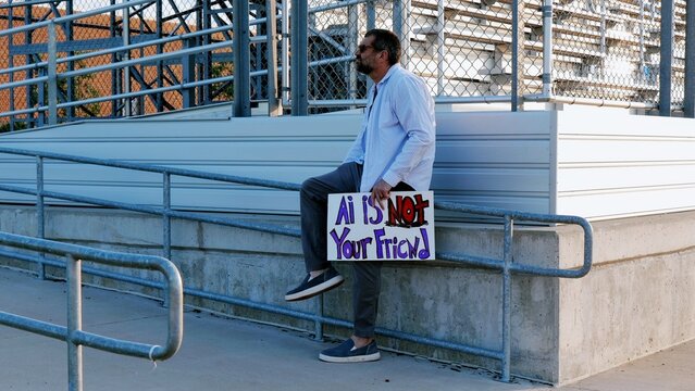 Protester holding a handmade sign warning against artificial intelligence, data centers, LLM therapy companionship addiction, big data, tech ethics
