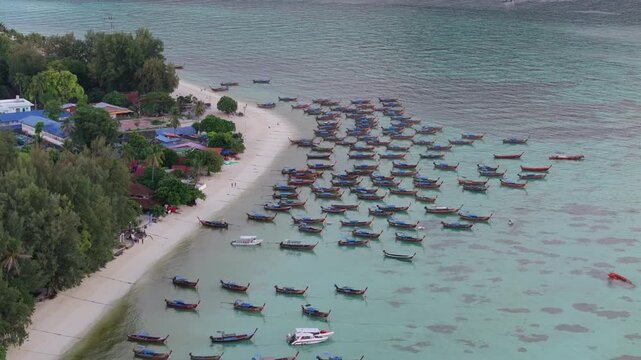 Aerial drone view of Koh Lipe island, Satun, Thailand. Turquoise sea, coral reefs, white sand beaches and traditional long-tail boats in the Andaman Sea.