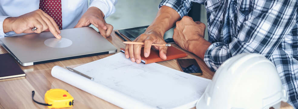 Banner Contractor construction engineer meeting on architect table at construction site. Businessman engineer manager discuss talk together foreman team builder using measure tape with copy space.