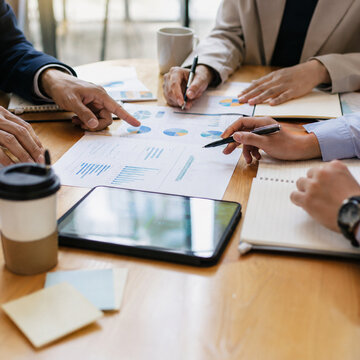 Business Meeting With Charts And Teamwork Hands