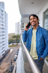Fototapeta premium Man calling on phone from urban balcony