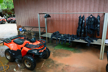 Orange atv quad vehicle protective gear armor jacket pants helmet outdoor adventure mud wet safety equipment bench drying rain recreation offroad fourwheeler transportation travel fun extreme © CoreRock