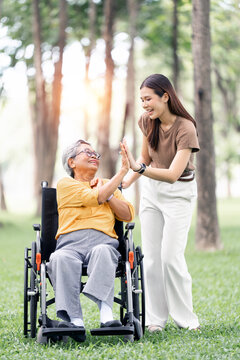 Happy Asian Senior Mother and Daughter Giving High Five in Park