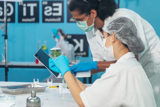 Two Asian scientist use microbiology microscope chemistry lab equipment. Scientist man woman working together team partner brainstorming in science laboratory. Biochemistry pharmaceutical study lab