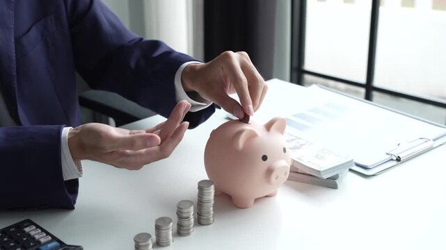 Businessman putting coin in piggy bank money saving concept